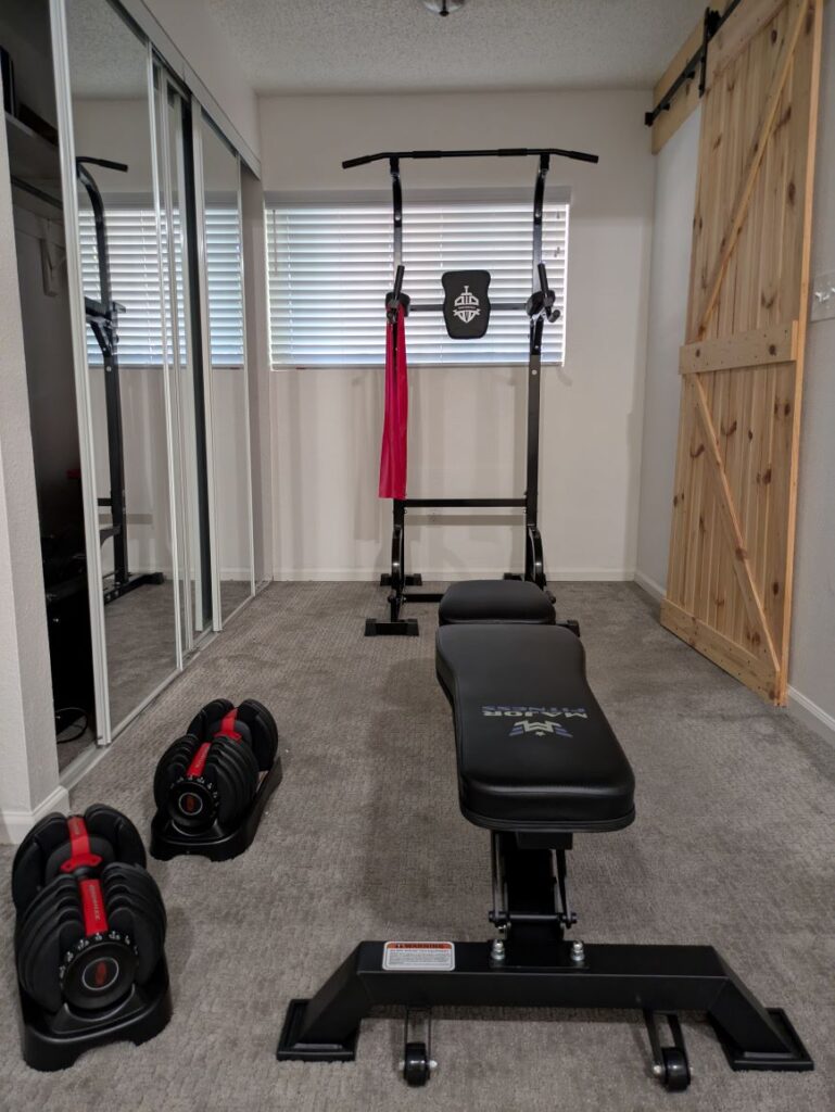 An example of our budget home gym that includes resistant bands, adjustable weights, a power towel, and a weight bench.